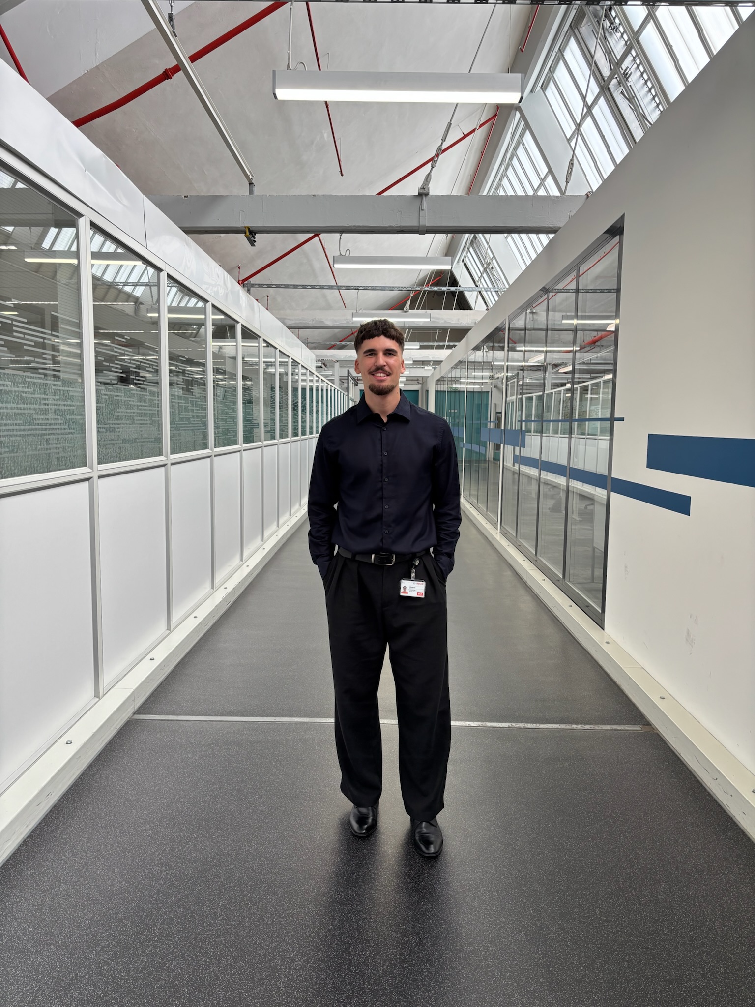 Portrait of Jonathan Fouquet standing in a bright lab corridor